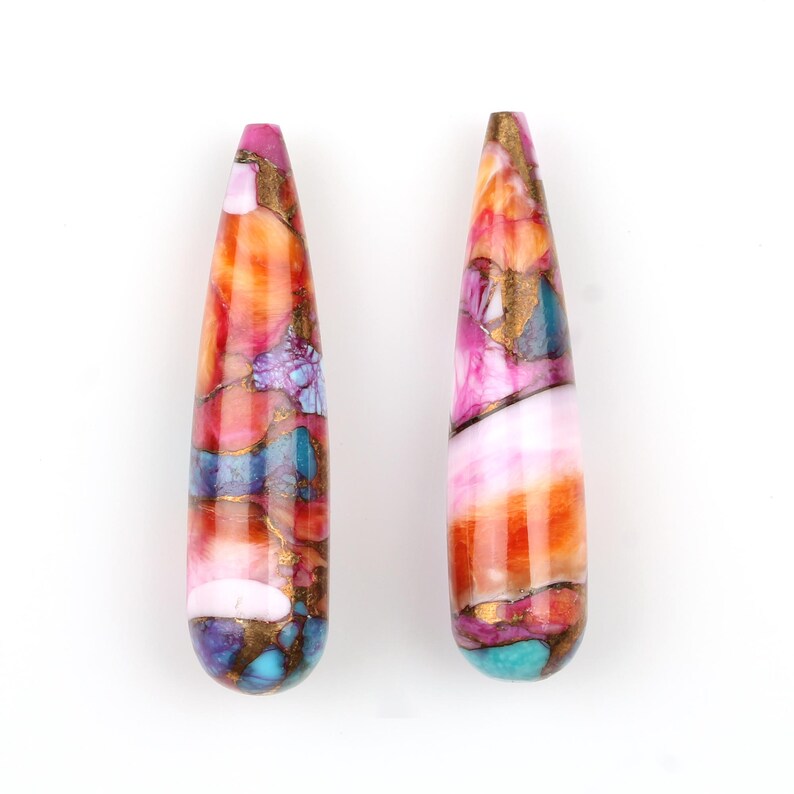 May include: Two teardrop-shaped pendants with a colorful, abstract pattern. The pendants are made of resin and feature a mix of pink, orange, blue, purple, and gold colors.