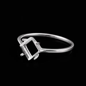 May include: A silver ring with a square setting, designed to hold a gemstone. The ring has a thin band and a detailed setting with prongs to secure the stone. The ring is displayed against a black background.