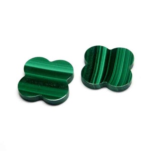 May include: Two green malachite stone clover shaped charms. The stones have a striated pattern.