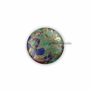 May include: A round, green, blue, and gold gemstone with a marbled pattern. Gems Bazaar India is printed on the stone.