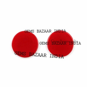 May include: Two red round game pieces with the text "Gems Bazaar India" printed on them.