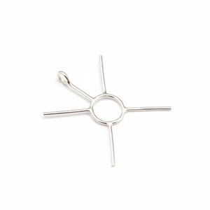 Puede incluir: Una herramienta de metal plateado con un centro circular y cuatro brazos rectos que se extienden hacia afuera. Un brazo tiene un bucle en el extremo. La herramienta está diseñada para un propósito específico.