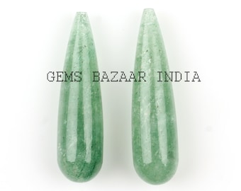 May include: Two green gemstone teardrop pendants, each with a smooth, polished surface.  GEMS BAZAAR INDIA is printed on the white background.