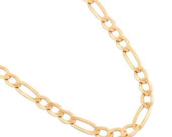 May include: A gold-colored Figaro chain necklace. The necklace features a pattern of elongated oval links alternating with smaller, circular links. The chain is displayed against a white background.
