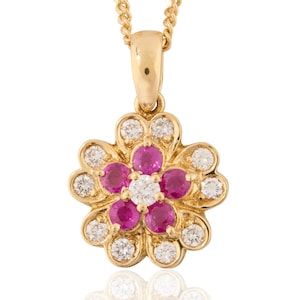 Peut inclure: Un collier pendentif en or avec un motif floral. Le pendentif comporte une pierre précieuse blanche centrale entourée de six pierres précieuses roses et douze pierres précieuses blanches. La chaîne du collier est en or.