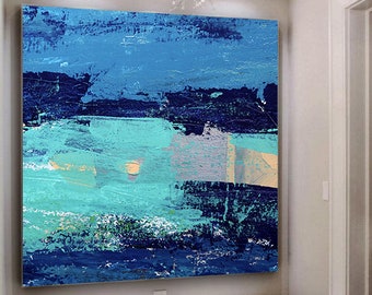 以下が含まれることがあります： 青、ターコイズ、白の筆致で描かれた抽象画。絵は白い壁と白いタイル張りの床のある部屋の壁にかけられている。手前に金属製の脚が付いた白いベンチが2つある。