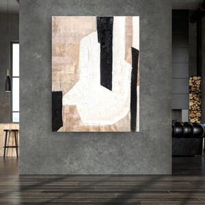 May include: Abstract painting with black and white lines and shapes on a beige background. The painting is hanging on a gray wall in a modern interior.