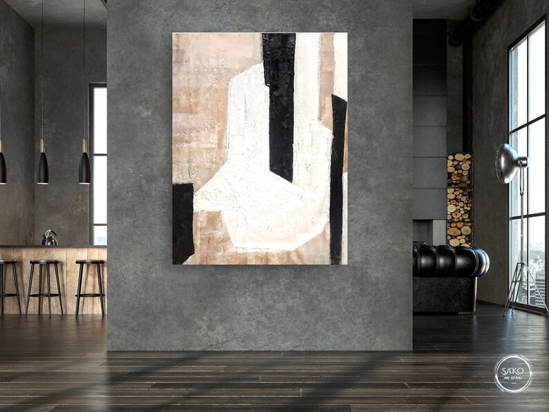 May include: Abstract painting with black and white lines and shapes on a beige background. The painting is hanging on a gray wall in a modern interior.