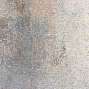 May include: A close-up of a textured, light gray canvas with subtle brown and blue brushstrokes. The canvas has a rough, uneven surface.