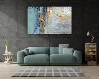 May include: A teal blue sofa with two pillows sits in front of a gray concrete wall with an abstract painting above it. The painting is a mix of blue, green, yellow, and white paint.
