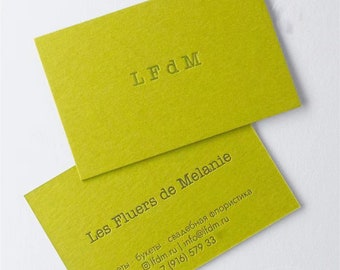 Könnte beinhalten: Eine grüne Visitenkarte mit dem Text "LFdM Les Fluers de Melanie" in einer Serifenschrift. Die Karte enthält auch die Kontaktinformationen: "Ifdm.ru | info@lfdm.ru +7 (916) 579 33" und den Text "цветы букеты свадебная флористика" in einer kleineren Schrift.