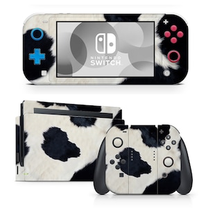 May include: A black and white cow print skin decal for a Nintendo Switch console and controllers. The decal features a realistic cowhide pattern with black spots on a white background.