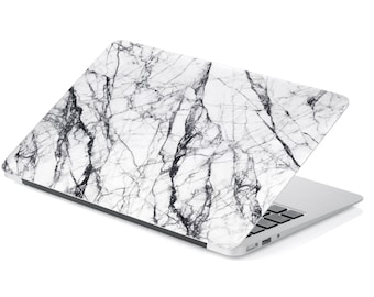 May include: A white laptop with a marble pattern on the lid. The laptop is closed and the lid is open at an angle.