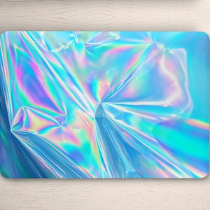 May include: A laptop with a holographic iridescent blue, pink, and green design.
