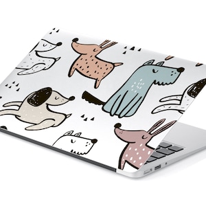 May include: A white laptop with a colorful pattern of cartoon dogs. The dogs are in various poses and colors, including brown, blue, and pink.
