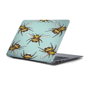 May include: A light blue laptop skin with a repeating pattern of yellow and brown bumblebees.
