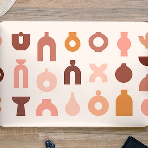 May include: A laptop computer with a white background and a pattern of abstract shapes in shades of brown, orange, and pink. The shapes are reminiscent of vases, bowls, and other geometric forms.