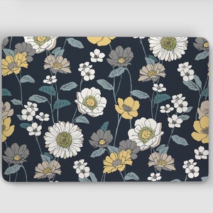 Könnte beinhalten: Eine Laptop-Haut mit einem Blumenmuster. Das Design zeigt weiße, gelbe und graue Blumen auf einem dunkelblauen Hintergrund.