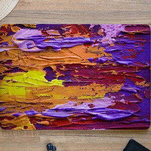 May include: Abstract painting with thick layers of purple, yellow, orange, and red paint. The paint is applied in a textured, brushstroke style.