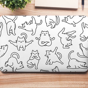 May include: A white laptop skin with a black and white repeating pattern of cats in various yoga poses. The cats are drawn in a simple, cartoon style.