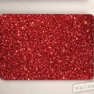 Könnte beinhalten: Rote Glitzer-Laptop-Haut. Die Haut ist einfarbig rot mit einem glitzernden Glitzer-Finish. Die Haut ist so konzipiert, dass sie auf einen Laptop passt.