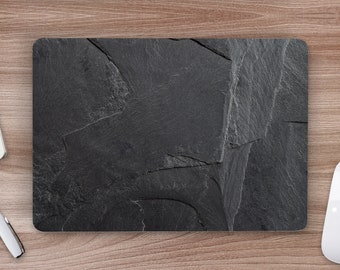 May include: A black slate mouse mat with a textured surface. The mouse mat is on a wooden surface.