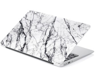 May include: A white laptop with a marble pattern on the lid. The laptop is closed and sitting on a white surface.