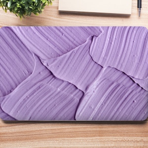 Puede incluir: Una piel para portátil de color morado con un diseño texturizado de pinceladas.