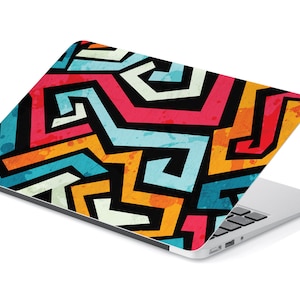 Könnte beinhalten: Ein Laptop mit einem farbenfrohen, abstrakten geometrischen Design auf dem Deckel. Das Design zeigt eine Mischung aus blauen, orangen, gelben, roten und weißen Farben.