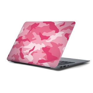 May include: A pink and white camouflage laptop skin. The skin is applied to the back of a silver laptop.