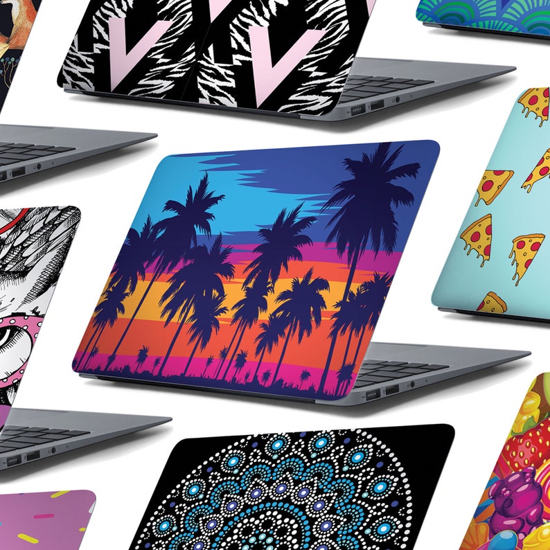 May include: A collection of laptop skins featuring a variety of designs, including a black and white zebra print with a pink letter V, a blue and orange sunset with palm trees, a blue and white mandala pattern, a blue and green geometric pattern, a blue background with pizza slices, and a colourful fruit and candy pattern.