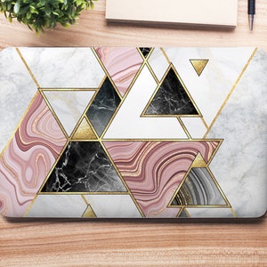 May include: A laptop skin with a geometric design featuring pink, white, black, and gold marble patterns. The design is made up of overlapping triangles.