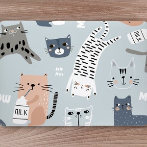 May include: A blue laptop skin with a repeating pattern of cartoon cats. The cats are in various poses, including drinking milk, jumping, and sitting. The text "Milk" appears on the skin.