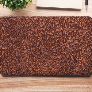 May include: A laptop computer with a brown and orange fur-like pattern on the cover.