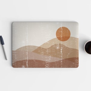 May include: A laptop skin with a minimalist design featuring a brown and orange sun setting behind a series of brown hills. The background is a light gray with a distressed texture.