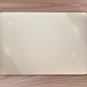 May include: A white laptop computer with a subtle glitter design on the lid. The laptop is on a wooden surface with a white mouse and a notebook and pen.
