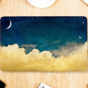 Peut inclure: Un ordinateur portable avec un motif de ciel et de nuages. Le motif présente une lune croissante, des étoiles et des nuages dans des tons de bleu, jaune et blanc.