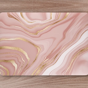 May include: Pink and gold marble laptop skin with a swirling pattern.