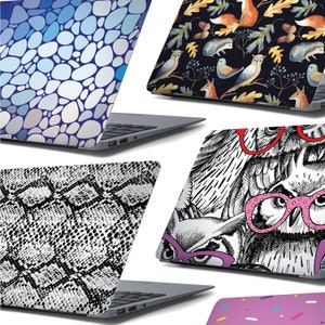 May include: Five different laptop skins with various designs. The skins feature a blue and white pebble pattern, a black and white owl pattern, a black and white snake skin pattern, a black background with watercolour owls, foxes, and leaves, and a pink background with white sprinkles.