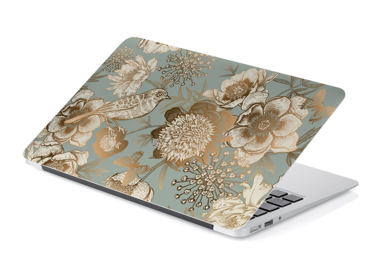 May include: A laptop computer with a floral design on the lid. The design features gold flowers and birds on a light blue background.