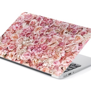 May include: A laptop computer with a pink floral design on the lid. The design features a variety of pink roses and other flowers.