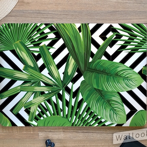 May include: A laptop skin with a tropical leaf pattern on a black and white geometric background. The skin features large green leaves with a white background and black diagonal stripes.