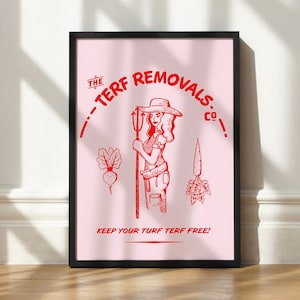 May include: Framed print with a pink background. It features a red illustration of a woman with a pitchfork, vegetables, and text that reads "The Turf Removals Co." and "Keep Your Turf Turf Free!"