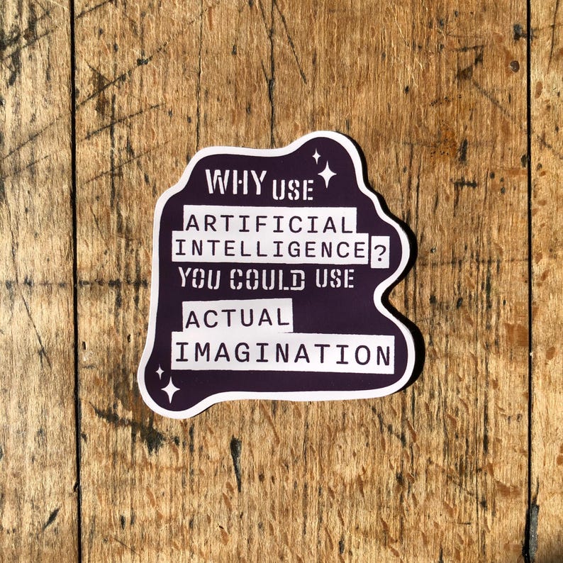 May include: A purple and white sticker with the text "WHY USE ARTIFICIAL INTELLIGENCE? YOU COULD USE ACTUAL IMAGINATION." The sticker has a unique shape and is set against a wooden background.