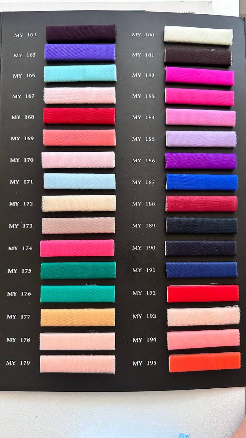 May include: A color chart with 22 fabric swatches. The swatches are arranged in two columns, with the numbers MY 164 through MY 179 on the left and MY 180 through MY 195 on the right. The swatches are a variety of colors, including purple, blue, pink, red, green, and yellow.