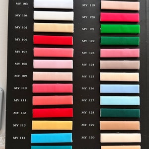 May include: A color chart with 16 fabric swatches, each labeled with a code. The swatches are arranged in two columns, with the codes "MY 100" through "MY 115" on the left and "MY 116" through "MY 131" on the right. The swatches are a variety of colors, including white, red, pink, blue, green, and yellow.