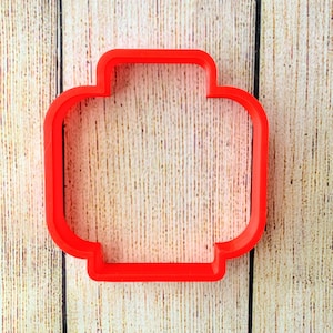 May include: Red plastic cookie cutter shaped like a Lego brick.