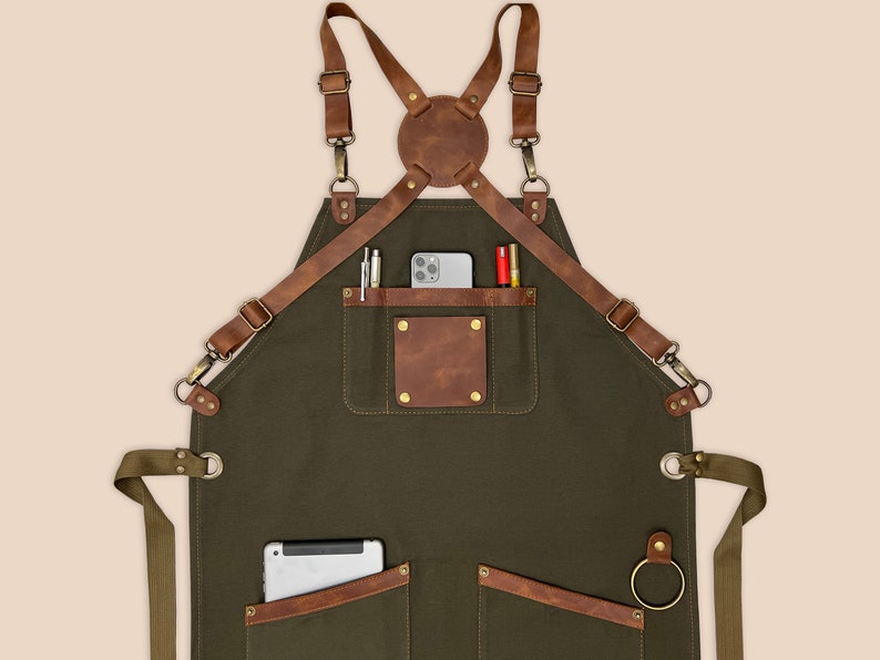 Personalized green work apron with leather pocket details, tool loop and durable canvas body