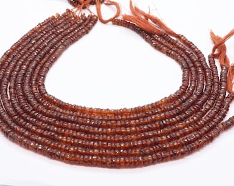 May include: A strand of brown gemstone beads, likely garnet, with a faceted finish. The beads are strung on a thin cord and have a tassel at the end. There are multiple strands of beads in the image.