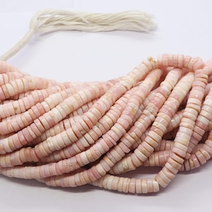 Pode incluir: Um fio de contas rosa e brancas em forma de disco. As contas s&atilde;o de uma cor pastel suave e parecem ser feitas de um material natural. As contas s&atilde;o enfiadas com um cord&atilde;o branco e s&atilde;o adequadas para a fabrica&ccedil;&atilde;o de joias.